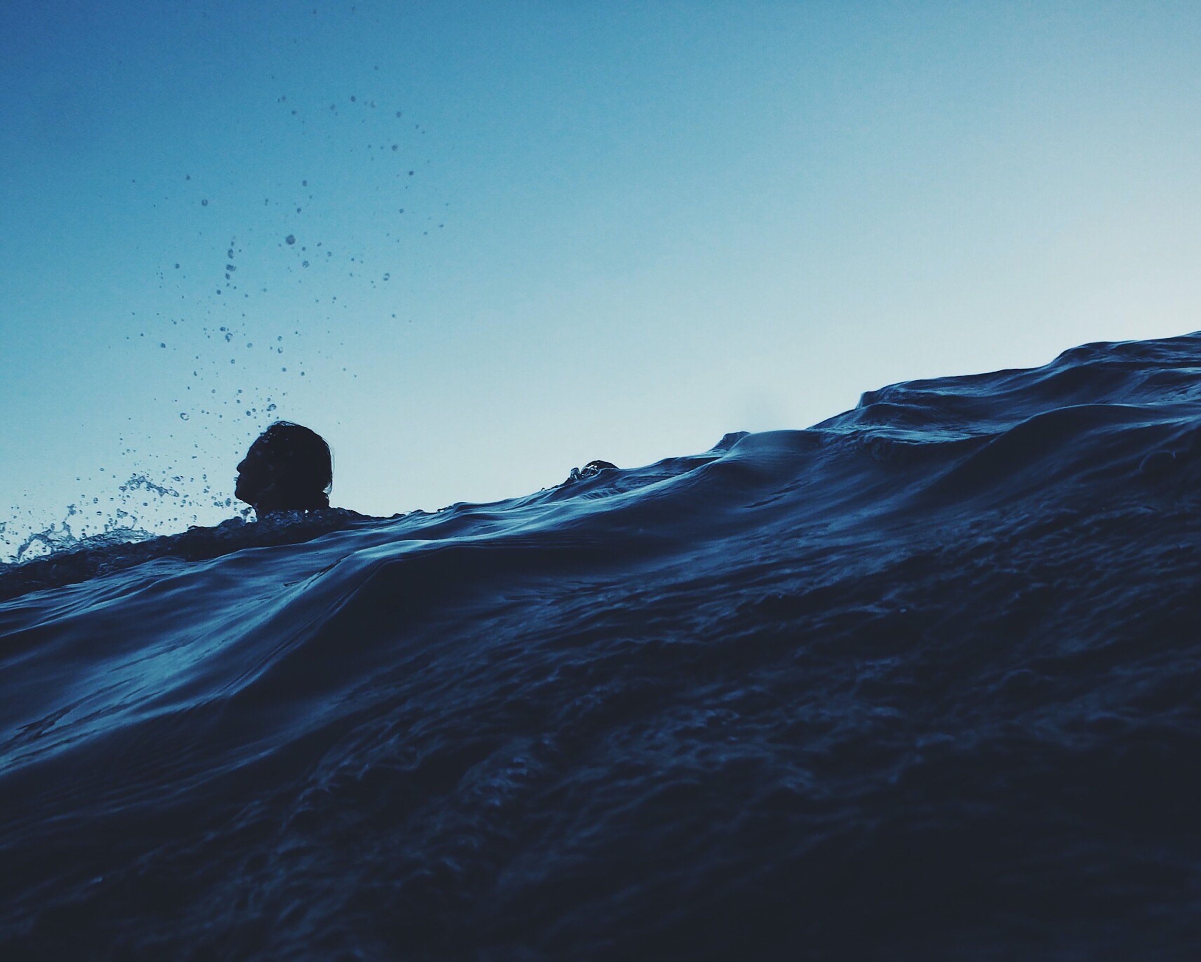 A figure struggling to swim in the sea.
